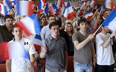 Members of France's far-right National Front wave French flags as they attend the party's summer youth congress in Frejus on September 7, 2014. photo credit: AFP/VALERY HACHE) Members of France's far-right National Front wave French flags as they attend the party's summer youth congress in Frejus on September 7, 2014. photo credit: AFP/VALERY HACHE)