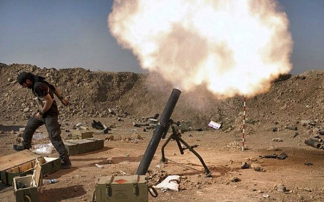 An Iraqi militia fighter from Shiite cleric Moqtada al-Sadr's Saraya al-Salam (Peace Brigade), fires a mortar during heavy clashes with Islamic State (IS) fighters in Tuz Khurmatu in Salaheddin province about 88 kilometres (55 miles) south of Kirkuk on August 31, 2014.  (photo credit: AFP/ JM Lopez) 
