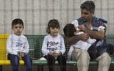 Refugees who were rescued off the coast of Cyprus rest in a holding area at the port of Limassol on September 25, 2014 (Photo credit: Andrew Caballero-Reynolds/AFP)
