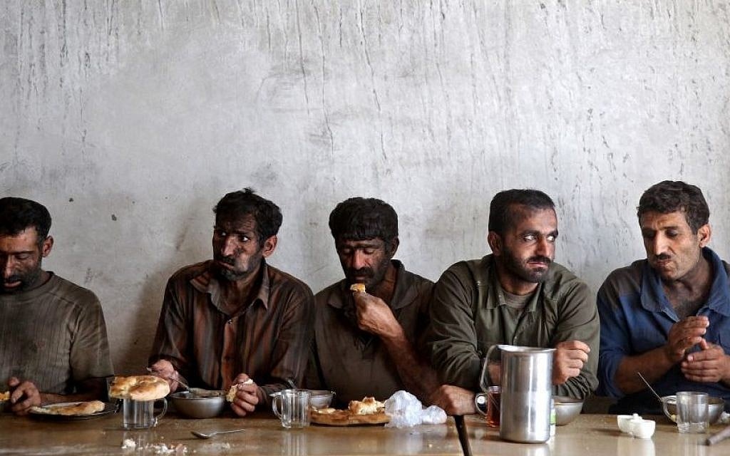 In this Tuesday, Aug. 19, 2014 photo, Iranian coal miners eat lunch at a mine near the city of Zirab 212 kilometers (132 miles) northeast of the capital Tehran, on a mountain in Mazandaran province, Iran. International sanctions linked to the decade-long dispute over Iran’s nuclear program have hindered the import of heavy machinery and modern technology in all sectors, and coal mining is no exception. (Photo credit: AP/Ebrahim Noroozi)