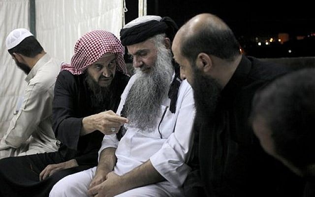 In this Wednesday, Sept. 24, 2014 photo, radical al-Qaida-linked preacher Abu Qatada, center, listens to the renowned jihadi ideologue, Abu Mohammed al-Maqdisi, second left, on the day Abu Qatada was released from Jordanian prison after an acquittal on security charges, in Amman, Jordan. (photo credit: AP photo/Mohammad Hannon) In this Wednesday, Sept. 24, 2014 photo, radical al-Qaida-linked preacher Abu Qatada, center, listens to the renowned jihadi ideologue, Abu Mohammed al-Maqdisi, second left, on the day Abu Qatada was released from Jordanian prison after an acquittal on security charges, in Amman, Jordan. (photo credit: AP photo/Mohammad Hannon)