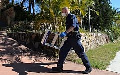 A police officer searches a house in Mount Gravatt, Brisbane, Australia, Thursday, Sept. 18, 2014. (Photo credit: AP/AAP Image, Dave Hunt)