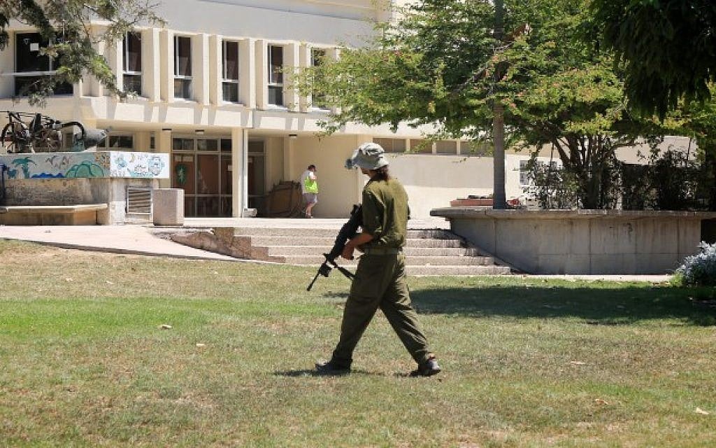 An Israeli soldier walks in Kibbutz Nahal Oz near the Gaza border after it was temporarily abandoned by residents after it was targeted by volleys of rockets from the Gaza Strip during Operation Protective Edge, summer 2014. (Edi Israel/Flash90)