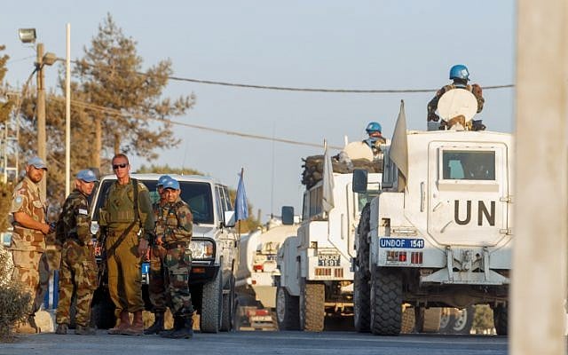 Illustrative: Members of the United Nations Disengagement Observer Force (UNDOF) are seen near an IDF soldier in the Israeli Golan Heights near the Quneitra crossing between Israel and Syria, on August 30, 2014. (Flash90) Illustrative: Members of the United Nations Disengagement Observer Force (UNDOF) are seen near an IDF soldier in the Israeli Golan Heights near the Quneitra crossing between Israel and Syria, on August 30, 2014. (Flash90)