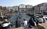 People sitting by the Grand Canal in Venice, Italy, on Thursday, September 25, 2014. (AP/Luca Bruno)