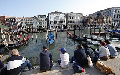 People sitting by the Grand Canal in Venice, Italy, on Thursday, September 25, 2014. (AP/Luca Bruno)