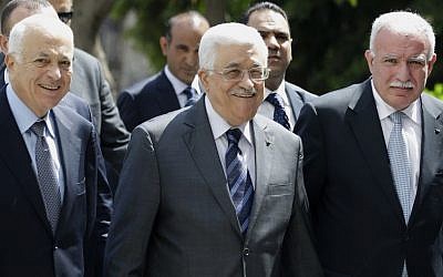 PA President Mahmoud Abbas (center), arrives with the Arab League's Secretary-General Nabil Elaraby (left), and Palestinian Foreign Minister Riyad al-Maliki (right) to attend a meeting of Arab foreign ministers at the Arab League headquarters in Cairo, Egypt, on Sunday, September 7, 2014. (photo credit: AP/Hassan Ammar)