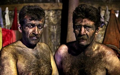 In this Wednesday, May 7, 2014 photo, Iranian coal miners pose for a photograph before taking a shower after a long day of work  more than minimum wage.(Photo credit: AP/Ebrahim Noroozi)
