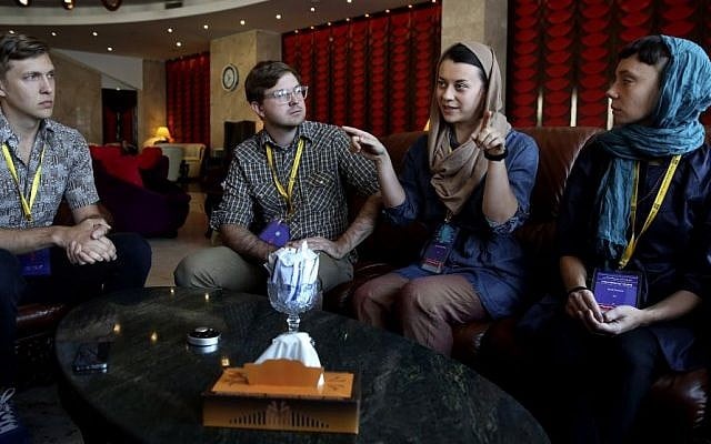 In this Tuesday, Sept. 16, 2014, American puppeteer Julia Miller, second right, speaks as her group members Sara Fornace, right, co-director Drew Dir, second left, and Kyle Vegter listen during an interview with The Associated Press two days prior to the group's performance for the Tehran Mobarak Puppet Festival in Iran. (Photo credit: AP/Vahid Salemi)