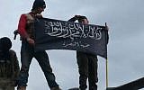 This Friday, Jan. 11, 2013 file citizen journalism image provided by Edlib News Network, ENN, which has been authenticated based on its contents and other AP reporting, shows rebels from al-Qaida affiliated Jabhat al-Nusra, also known as the Nusra Front, waving their brigade flag as they step on the top of a Syrian air force helicopter, at Taftanaz air base that was captured by the rebels, in Idlib province, northern Syria. (Photo credit: AP/Edlib News Network ENN, File)