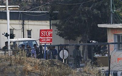 In this file photo taken Friday, Aug. 29, 2014, an armed group of men, not specified which group of rebels, gather at Syria's Quneitra border crossing between Syrian- and Israeli-controlled parts of the Golan Heights. (Photo credit: AP/Ariel Schalit, File)