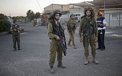 In this file photo taken Wednesday, August 27, 2014, Israeli soldiers secure an area where a mortar which was fired during clashes between Syrian rebels and President Bashar Assad’s forces in the Quneitra province hit in a community in the Israeli-controlled Golan Heights. (photo credit: AP/Ariel Schalit)