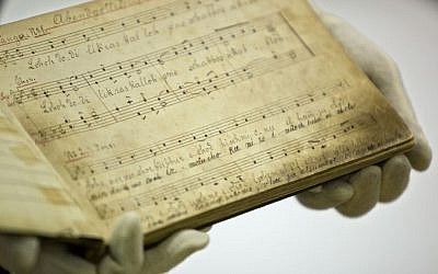 Yad Vashem archive director Haim Gertner shows a musical score with German lyrics at the Yad Vashem Holocaust memorial archives in Jerusalem. September 8, 2014. (photo credit: AP/Sebastian Scheiner)