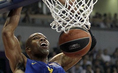 In this Thursday, March 20, 2014 file photo, Alex Tyus of Israel's BC Maccabi Electra dunks a ball during their Euroleague Top 16 basketball match against Partizan, in Belgrade, Serbia, Thursday, March 20, 2014. With his Maccabi Tel Aviv team set to face LeBron James in his first game back for the Cleveland Cavaliers on Oct. 5, 2014, Alex Tyus, a 6-9 power forward from St. Louis, has an important decision to make -- whether to fast the previous day for the Jewish holy day of Yom Kippur. American Jews have long found a basketball refuge in Israel but the Jewish state has never seen anything like Tyus before: an African-American standout from a major college program with no previous link to the religion who decided, along with his future wife, to embrace the faith and set off on a path that led him to the Israel national team and the best team in the country. (photo credit: AP Photo/Darko Vojinovic, File)