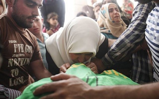 The mother of Amer Abu Aysha kisses the lifeless body of her son after Israeli troops shot dead Abu Aysha and Marwan Qawasmeh in the West Bank city of Hebron, on Tuesday, September 23, 2014. (photo credit: AP/Nasser Shiyukhi) The mother of Amer Abu Aysha kisses the lifeless body of her son after Israeli troops shot dead Abu Aysha and Marwan Qawasmeh in the West Bank city of Hebron, on Tuesday, September 23, 2014. (photo credit: AP/Nasser Shiyukhi)