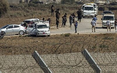 Al-Qaida-linked Syrian militants gather around vehicles carrying UN peacekeepers from Fiji Thursday, Sept. 11, 2014 (photo credit: AP Photo/Gil Eliyahu) 