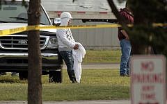 Employees wait in the parking lot as police investigate a shooting at Vaughn Foods in Moore, Oklahoma, on Thursday, September 25, 2014. Police said Friday a man who had been fired from the food-processing plant beheaded a woman with a knife and was attacking another worker when he was shot and wounded by a company official. (photo credit: AP/The Oklahoman, Steve Sisney)