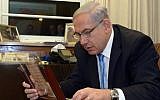 Prime Minister Benjamin Netanyahu examines what is said to be the world's oldest prayer book, now on display at the Bible Lands Museum, 2104. (photo credit: Chaim Tzach)