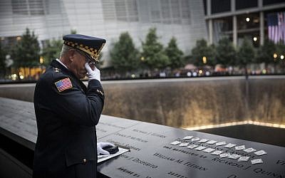 Sam Pulia, mayor of Westchester, Ill., and a former police officer of the same town, mourns over the name of his cousin, New York firefighter Thomas Anthony Casoria, who was killed in the South Tower in the attacks of Sept. 11, 2001, prior to the the memorial observances held at the site of the World Trade Center in New York, Thursday, Sept. 11, 2014 (photo credit: AP/Andrew Burton, Pool)