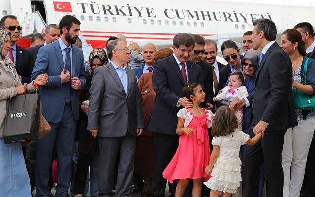 Turkish Prime Minister Ahmet Davutoglu, center right, stands with freed hostages at the airport in Ankara, Turkey, Saturday, Sept. 20, 2014. (Photo credit: AP) Turkish Prime Minister Ahmet Davutoglu, center right, stands with freed hostages at the airport in Ankara, Turkey, Saturday, Sept. 20, 2014. (Photo credit: AP)