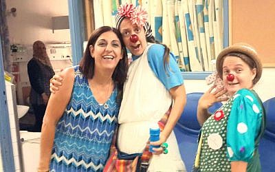 Ilana Levy, left, with two medical clowns doing their rounds in the pediatric unit. (photo credit: Debra Kamin/Times of Israel)