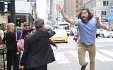Meir Kalmanson attempts to give a high-five to a commuter hailing a taxi in New York City. (photo credit: screen capture YouTube)
