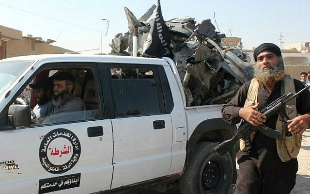 An Islamic State gunman walks past a pickup truck loaded with the wreckage of a Syrian government aircraft shot down by militants over the Syrian town of Raqqa on September 16, 2014. (photo credit: STR/AFP) An Islamic State gunman walks past a pickup truck loaded with the wreckage of a Syrian government aircraft shot down by militants over the Syrian town of Raqqa on September 16, 2014. (photo credit: STR/AFP)