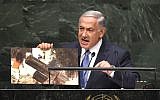 Prime Minister Benjamin Netanyahu holds up a photo of a purported Hamas rocket as he addresses the 69th Session of the UN General Assembly, September 29, 2014, in New York. (photo credit: AFP/Timothy A. Clary)