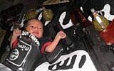 A baby is seen lying on an Islamic State flag surrounded by weaponry (Photo credit: Courtesy)