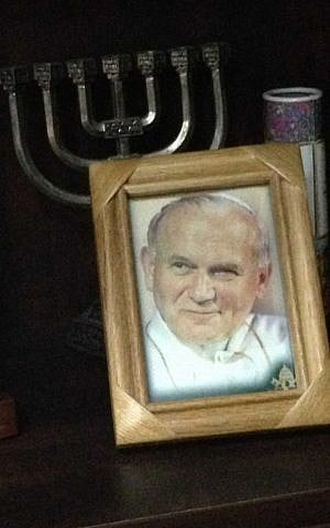The Jewish former-priest keeps a menorah next to a photo of Pope John Paul II on his bookshelf in his Jerusalem home. (photo credit: Renee Ghert-Zand)