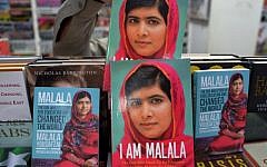 A Pakistani customer picks up a biography of Malala Yousafzai at a bookstore in Islamabad on October 10, 2014. Malala Yousafzai was hailed as the "pride of Pakistan" by Prime Minister Nawaz Sharif for winning the Nobel Peace Prize, as a former fellow pupil said the award was a victory for every girl in the country. (photo credit: AFP/Aamir QURESHI)