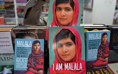 A Pakistani customer picks up a biography of Malala Yousafzai at a bookstore in Islamabad on October 10, 2014. Malala Yousafzai was hailed as the "pride of Pakistan" by Prime Minister Nawaz Sharif for winning the Nobel Peace Prize, as a former fellow pupil said the award was a victory for every girl in the country. (photo credit: AFP/Aamir QURESHI)