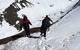 In this handout photograph released by the Nepal Army on October 17, 2014, a survivor injured in a snowstorm is carried on a stretcher by Nepal Army personnel to an army helicopter in the Manang district along the Annapurna Circuit Trek. (Photo credit: AFP/NEPAL ARMY)