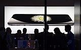 Store attendants help customers at an Apple store selling the iPhone 6 in Beijing on October 23, 2014. (photo credit: Greg Baker/AFP)