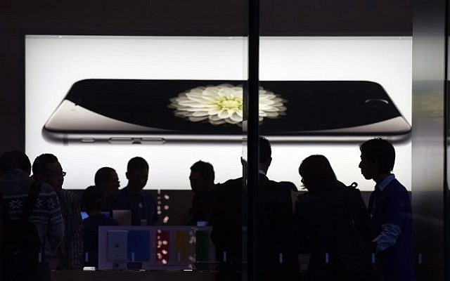 Store attendants help customers at an Apple store selling the iPhone 6 in Beijing on October 23, 2014. (photo credit: Greg Baker/AFP) Store attendants help customers at an Apple store selling the iPhone 6 in Beijing on October 23, 2014. (photo credit: Greg Baker/AFP)