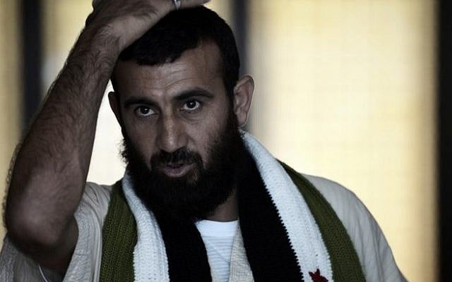Wounded Syrian rebel Abdulkarim al-Naseef wears a scarf with symbols of the old Syrian flag, now used by the opposition, as he stands at a hotel lobby near Mecca's Grand Mosque on October 1, 2014 during the annual hajj pilgrimage. (AFP PHOTO/MOHAMMED AL-SHAIKH) Wounded Syrian rebel Abdulkarim al-Naseef wears a scarf with symbols of the old Syrian flag, now used by the opposition, as he stands at a hotel lobby near Mecca's Grand Mosque on October 1, 2014 during the annual hajj pilgrimage. (AFP PHOTO/MOHAMMED AL-SHAIKH)