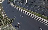 A man rides his bicycle on a car-free highway in Jerusalem during the Jewish High Holiday of Yom Kippur on October 4, 2014 (Menahem Kahana/AFP)