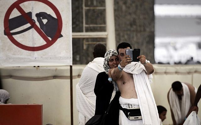 Muslim pilgrims pose for a selfie during the "Jamarat" ritual, the stoning of Satan, in Mina near the holy city of Mecca, on October 4, 2014. (photo credit: AFP/Mohammed al-Shaikh) Muslim pilgrims pose for a selfie during the "Jamarat" ritual, the stoning of Satan, in Mina near the holy city of Mecca, on October 4, 2014. (photo credit: AFP/Mohammed al-Shaikh)