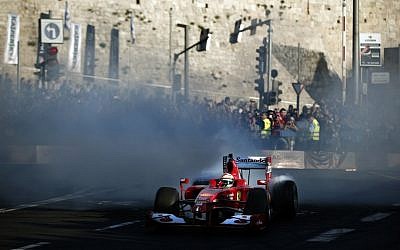 Three-time F1 Grand Prix winner Giancarlo Fisichella, of Italy, drives his Ferrari Formula 1 car below the ancient walls of Jerusalem's Old City on October 6, 2014, during the second Jerusalem F1 Peace Roadshow. (photo credit: AFP PHOTO / THOMAS COEX)