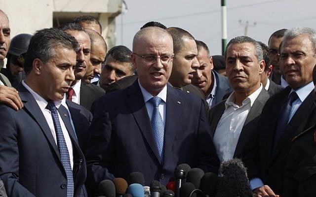 Palestinian Authority Prime Minister Rami Hamdallah (center) delivers a speech during a tour to some of the areas worst hit by the 50-day war between Israel and Gaza in July and August, 2014, during a visit to the Gaza Strip, on October 9, 2014. (photo credit: AFP/Said Khatib) Palestinian Authority Prime Minister Rami Hamdallah (center) delivers a speech during a tour to some of the areas worst hit by the 50-day war between Israel and Gaza in July and August, 2014, during a visit to the Gaza Strip, on October 9, 2014. (photo credit: AFP/Said Khatib)