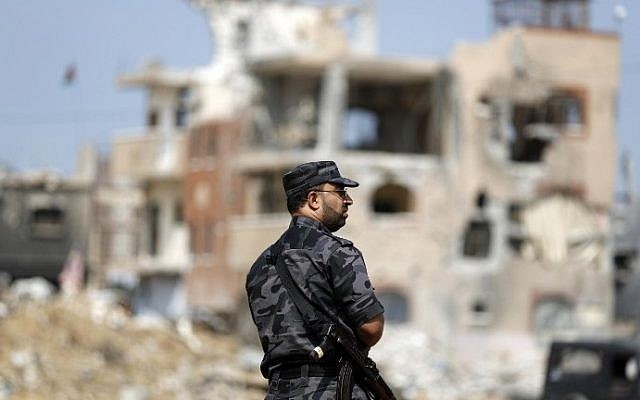 A Palestinian Hamas security officer stands guard as Palestinian Authority Prime Minister Rami Hamdallah (unseen) arrives to tour some of the areas worst hit by the 50-day war between Israel and Gaza militants in July and August, on October 9, 2014. (photo credit: Mohammed Abed/AFP)