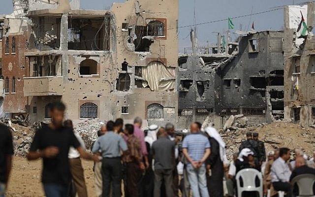 Palestinians await the arrival of Palestinian Authority Prime Minister Rami Hamdallah (unseen) during a tour to some of the areas worst hit by the 50-day war between Israel and Gaza in July and August, during a visit to the Shejaiya neighborhood of Gaza City, on October 9, 2014. (photo credit: Mohammed Abed/AFP) Palestinians await the arrival of Palestinian Authority Prime Minister Rami Hamdallah (unseen) during a tour to some of the areas worst hit by the 50-day war between Israel and Gaza in July and August, during a visit to the Shejaiya neighborhood of Gaza City, on October 9, 2014. (photo credit: Mohammed Abed/AFP)