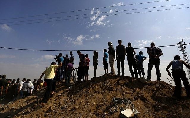 Palestinians await the arrival of Palestinian Authority Prime Minister Rami Hamdallah (unseen) during a visit to the Shejaiya neighborhood of Gaza City, on October 9, 2014. (photo credit: Mohammed Abed/AFP) Palestinians await the arrival of Palestinian Authority Prime Minister Rami Hamdallah (unseen) during a visit to the Shejaiya neighborhood of Gaza City, on October 9, 2014. (photo credit: Mohammed Abed/AFP)