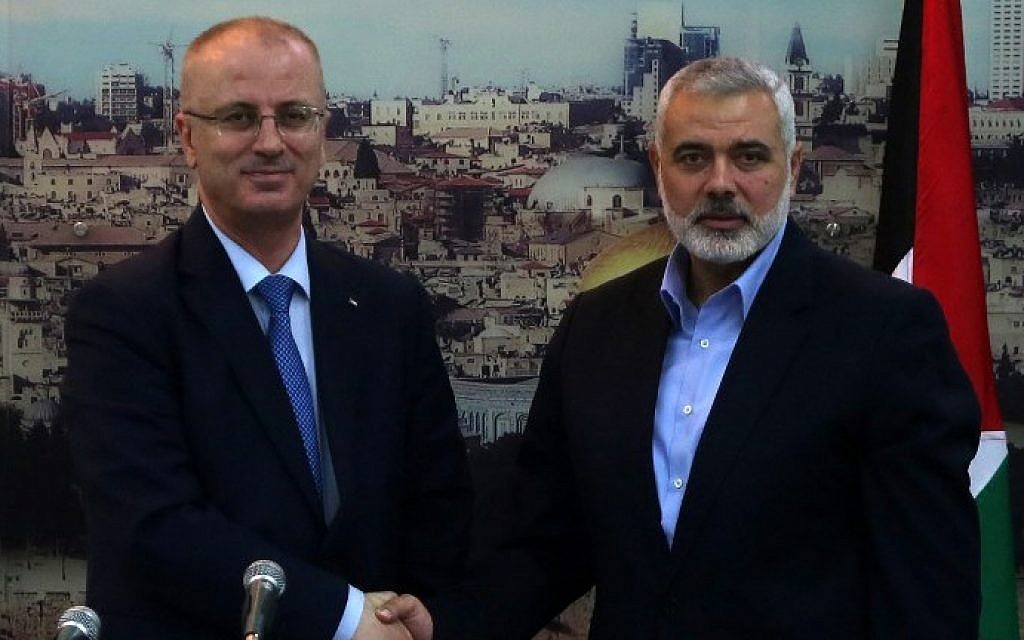 Hamas leader Ismail Haniyeh (right) shakes hands with Palestinian Authority Prime Minister Rami Hamdallah at Haniyeh's house in Gaza City, October 9, 2014.(AFP/Said Khatib)