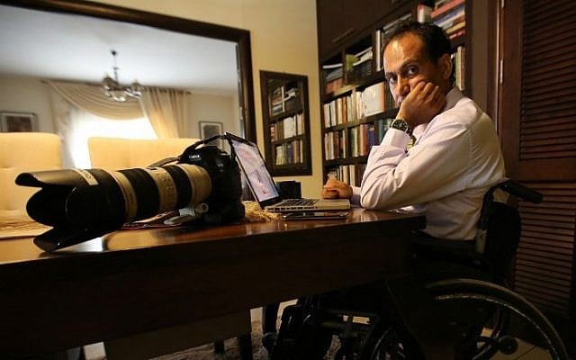 Palestinian photographer Osama Silwadi poses for a picture in the West Bank city of Ramallah on September 10, 2014. (photo credit: Abbas Momani/AFP)