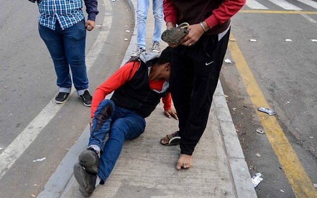 An Egyptian policeman in plain clothes sits on the pavement after he was injured during a bomb explosion outside the main gate of Cairo University that wounded at least nine people including a senior officer on October 22, 2014. (photo credit: AFP PHOTO /MAHMUD HASAN) An Egyptian policeman in plain clothes sits on the pavement after he was injured during a bomb explosion outside the main gate of Cairo University that wounded at least nine people including a senior officer on October 22, 2014. (photo credit: AFP PHOTO /MAHMUD HASAN)