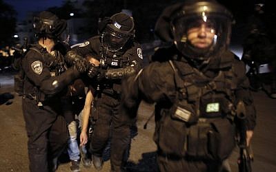 Israeli riot police officers detain a Palestinian youth during clashes in the East Jerusalem neighborhood of Silwan on October 26, 2014 (photo credit: AFP/AHMAD GHARABLI)
