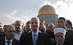 File: Palestinian Prime Minister Rami Hamdallah (center) stands next to the Mufti of Jerusalem Mohammed Hussein (right) outside Jerusalem's Dome of the Rock mosque on October 27, 2014. (AFP/Ahmad Gharabli)