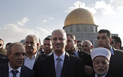 File: Palestinian Prime Minister Rami Hamdallah (center) stands next to the Mufti of Jerusalem Mohammed Hussein (right) outside Jerusalem's Dome of the Rock mosque on October 27, 2014. (AFP/Ahmad Gharabli)
