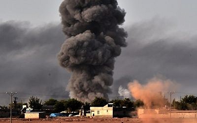 Smoke rises from the the Syrian town of Ayn al-Arab, known as Kobani by the Kurds, after a strike from the US-led coalition as it seen from the Turkish - Syrian border in the southeastern village of Mursitpinar, Sanliurfa province, on October 13, 2014. (Photo credit: AFP/ARIS MESSINIS)